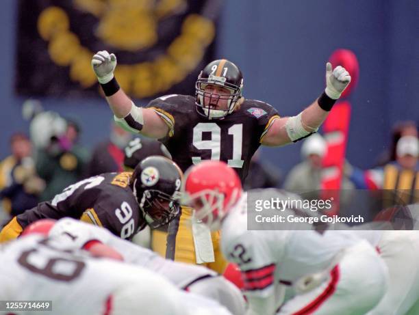 Linebacker Kevin Greene of the Pittsburgh Steelers signals as defensive lineman Brentson Buckner looks on from the line of scrimmage during a playoff...