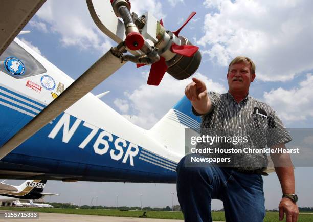 Chief Pilot Malcom Williams points out a rotary atomizer on a Piper Aztec twin engine airplane that will be used to spray Dibrom insecticide over...