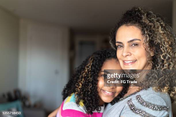 portrait of mother and daughter embracing - parent stock pictures, royalty-free photos & images