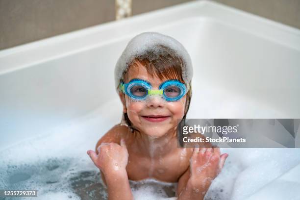 little boy with swimming goggles in bathtub - bubblebath stock pictures, royalty-free photos & images