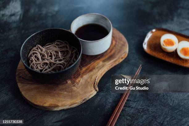 traditional japanese cold soba noodles with soft boiled egg on dark background - buckwheat stock pictures, royalty-free photos & images