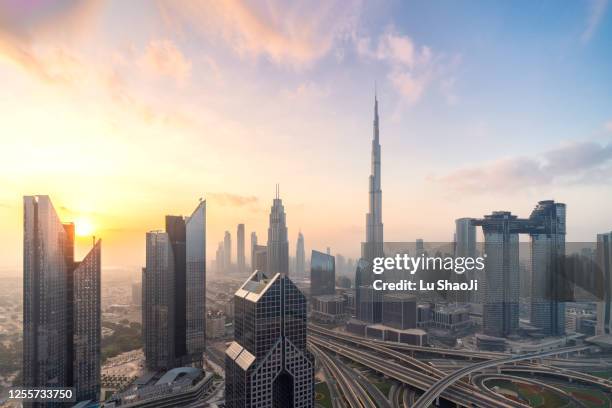 aerial view of city skyline and cityscape at sunset in dubai uae. - burj khalifa stock-fotos und bilder