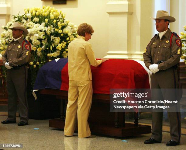 Jane Hickie places her hand on the casket of former Texas Governor Ann Richards during a memorial ceremony for the governor as two Texas Department...