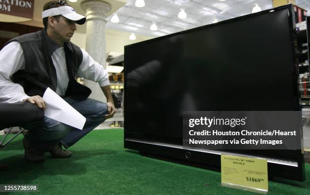 Joel Riddle looks over the Samsung 56'" HD DLP television he purchased at the Fry's Electronics store at 11565 Southwest Freeway in Houston, Texas...