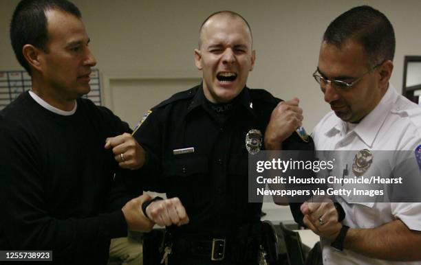 Pearland Police Officer George Dacy reacts after being shocked by a Taser gun during the Pearland Police Department's Taser training class while...