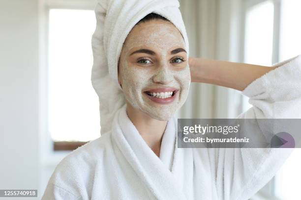 young woman standing with a facial mask - facial stock pictures, royalty-free photos & images