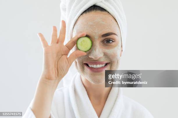 young woman playing with cucumber slices - woman facial expression stock pictures, royalty-free photos & images