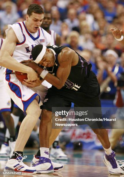 Kansas' Sasha Kaun and Kansas State's Cartier Martin wrestle for the ball during the first half of Phillips 66 Big 12 Men's Basketball Championship...