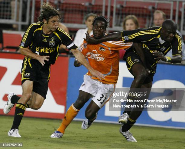 The Houston Dynamo's Joseph Ngwenya is blocked by the Columbus Crew's Frankie Hejduk and Ezra Hendrickson during the first half at Robertson Stadium...