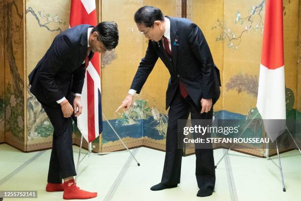 Britain's Prime Minister Rishi Sunak shows off his socks to Japanese Prime Minister Fumio Kishida, which has the name of Kishida's favorite baseball...