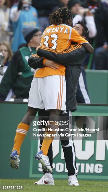 The Houston Dynamo's Joseph Ngwenya embraces teammate Brian Ching after scoring a goal against the New England Revolution's during the second half of...
