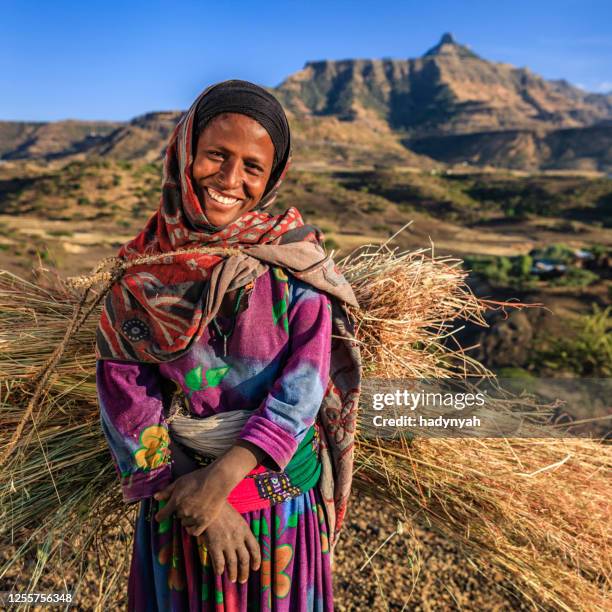 femme africaine heureuse portant la paille, afrique de l’est - east africa photos et images de collection