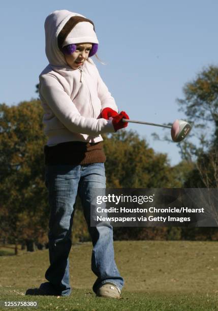 Nine-year-old Mia Copeland watches her tee shot while golfing with her grand parents Karen and Gene Ellison at Hermann Park Golf Course Tuesday, Jan....