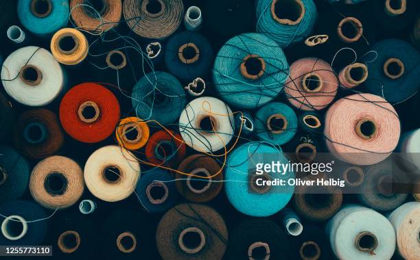 composition of sewing spools with colorful vibrant threads from above - materiale tessile foto e immagini stock