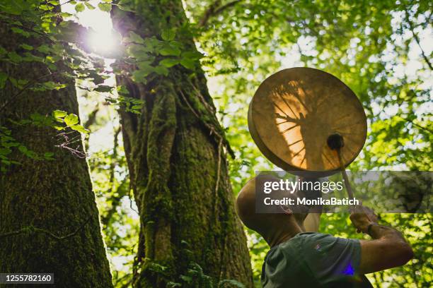 adult man playing shamanic drum - tambourine stock pictures, royalty-free photos & images