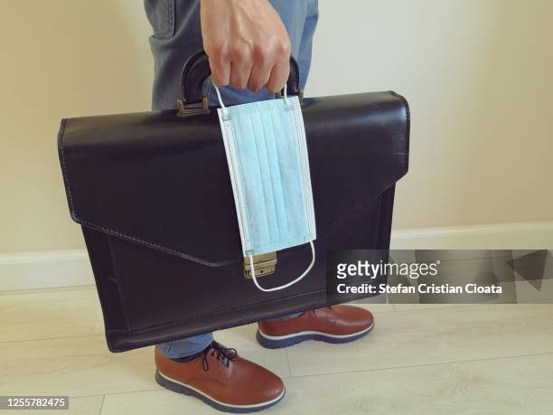 man with a briefcase and a surgical mask - rinviare la palla foto e immagini stock
