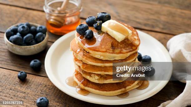 breakfast pancakes with blueberries, butter and honey - pancake stock pictures, royalty-free photos & images