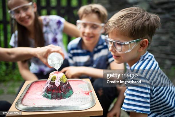 family testing volcano school project in back yard - chemistry model stock pictures, royalty-free photos & images