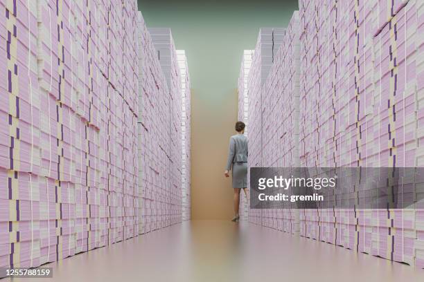 businesswoman walking between stacks of money - millionnaire stock pictures, royalty-free photos & images