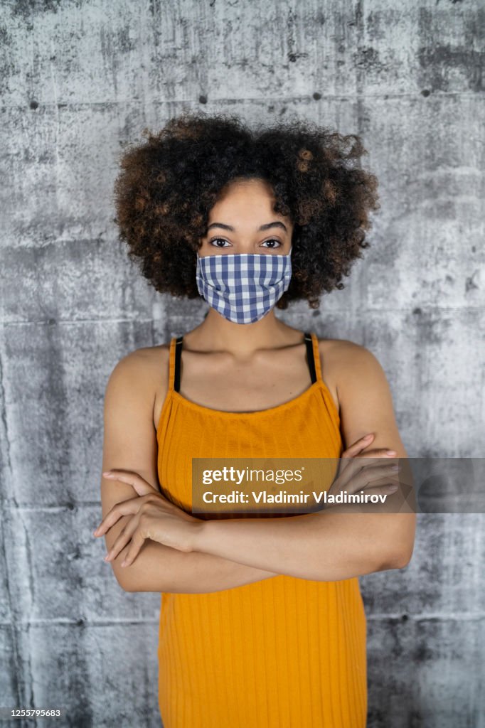 Portrait of a young afro woman wearing face mask to protect herself in time of epidemic