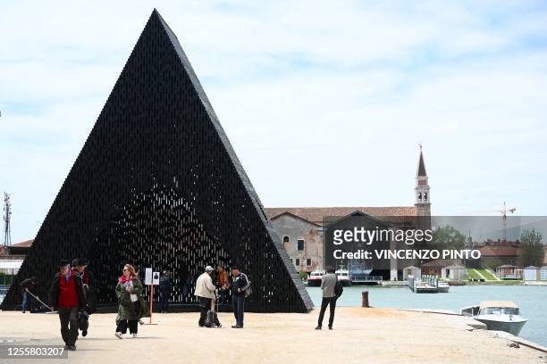 Visitors look at the installation "KwaeE" by Adjaye Associated at the 18th International Architecture Exhibition in Venice on May 18 during a press...