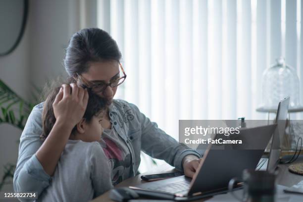 mother comforting daughter while working from home - fish out of water stock pictures, royalty-free photos & images