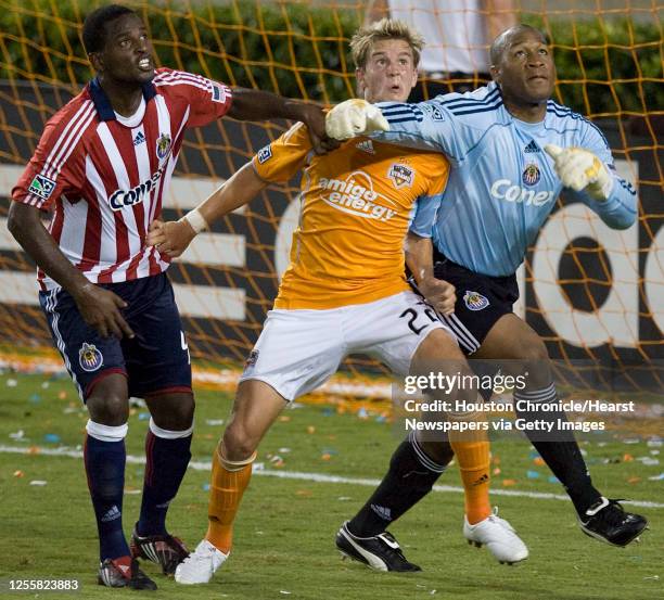 The Houston Dynamo's Stuart Holden and Chivas USA's Shavar Thomas and Zach Thornton tangle up during the second half of MLS game action at Robertson...