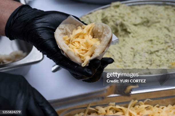 Woman prepares the traditional Venezuelan food known as arepas during the presentation of the French translation of the book by Venezuelan Ricardo...