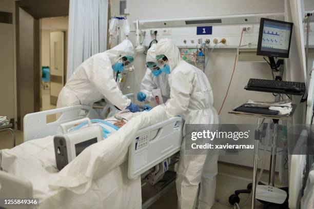 equipo médico intubando al paciente covid-19 en sala de emergencias - intubation fotografías e imágenes de stock