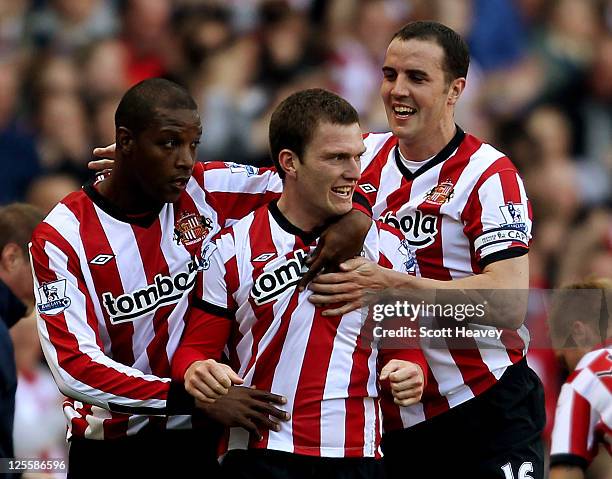 Titus Bramble and John O'Shea celebrate with Craig Gardner after he scored their third goal during the Barclays Premier League match between...