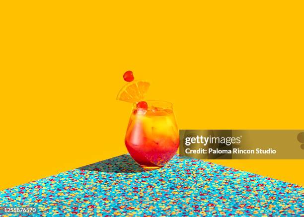 red and yellow cocktail shot over a graphic colorful background - tequila sunrise stockfoto's en -beelden