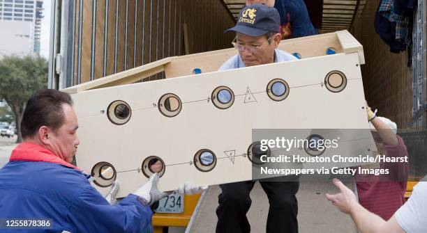 Tim Vo helps unload pieces of the Sacred Heart Co-Cathedral's new organ containing 5,499 pipes which will take nearly six months to complete the...