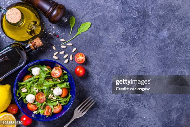 preparing and seasoning a fresh salad - table top view stock pictures, royalty-free photos & images