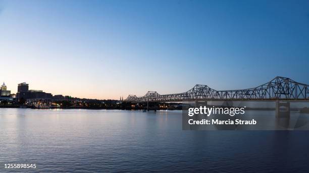 sunset and skyline and bridge spanning the illinois river at peoria, illinois - peoria illinois stock pictures, royalty-free photos & images