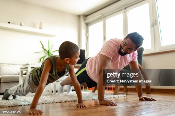 padre e hijo, haciendo ejercicio en casa - kids fitness fotografías e imágenes de stock