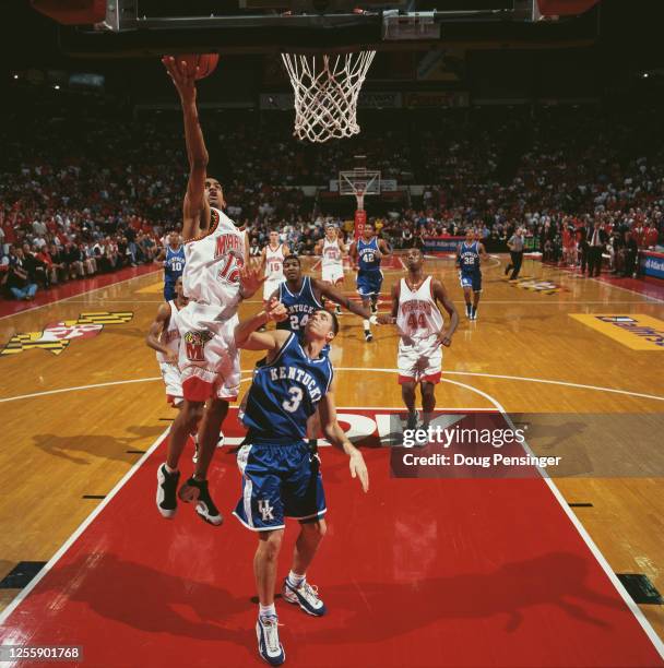 Drew Nicholas,Guard for the University of Maryland Terrapins makes a one handed layup into the basket to score over JP Blevins of the University of...