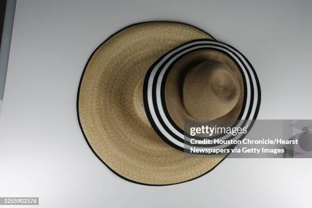 Eric Javits khaki sun hat with striped edge, $295, and Kokin large straw hat with black trim, $295, Tootsies.