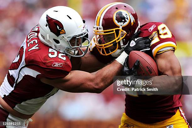 Running back Roy Helu of the Washington Redskins is forced out of bounds by linebacker Stewart Bradley of the Arizona Cardinals during the second...