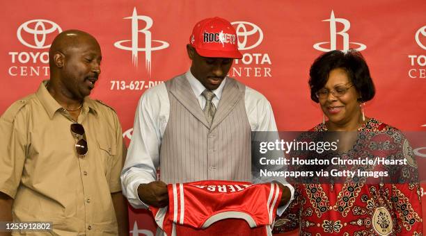 The Houston Rockets first round draft pick Patrick Patterson looks over his jersey with his mother Tywanna Patterson and father Buster Patterson...