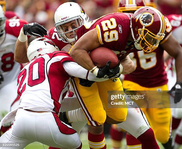 Washington Redskins running back Roy Helu is tackled by Arizona Cardinals cornerback A.J. Jefferson and linebacker Stewart Bradley during the first...