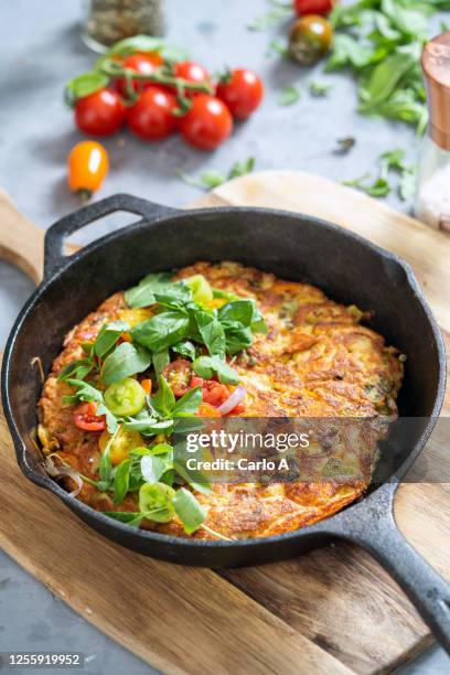 frittata or omelette with zucchini and tomatoes in a cast iron skillet - frittata stock pictures, royalty-free photos & images