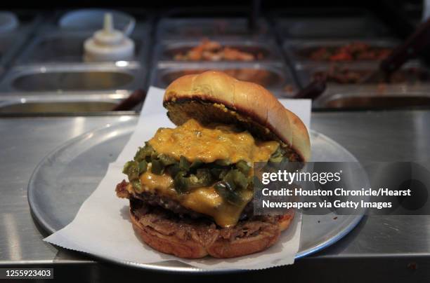 The Houston burger which includes Onion Bacon Jam, Fancy Lawnmower Ale Mustard, bread and butter jalapenos and cheddar cheese at Burger Guys...