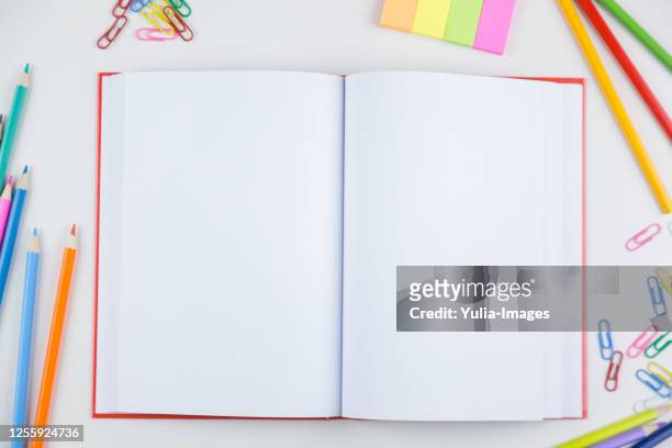 open blank book surrounded by colored pencils - reading glasses top view stock pictures, royalty-free photos & images