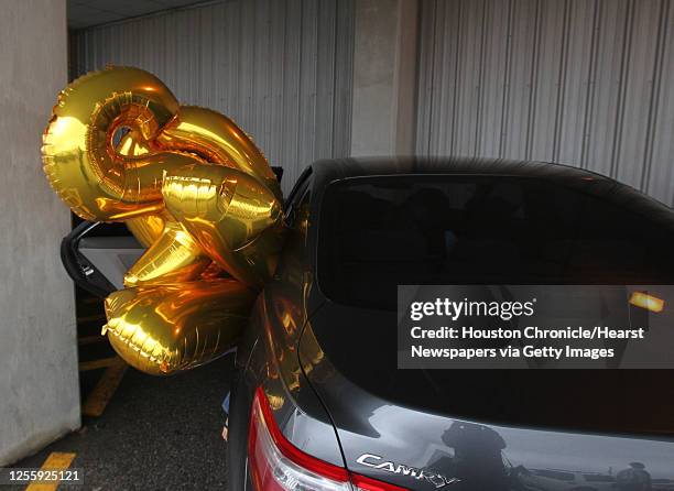 Michelle Kent loads 2011 balloons into her car after purchasing the balloons for a party while shopping for New Year's party supplies at Arnie's...