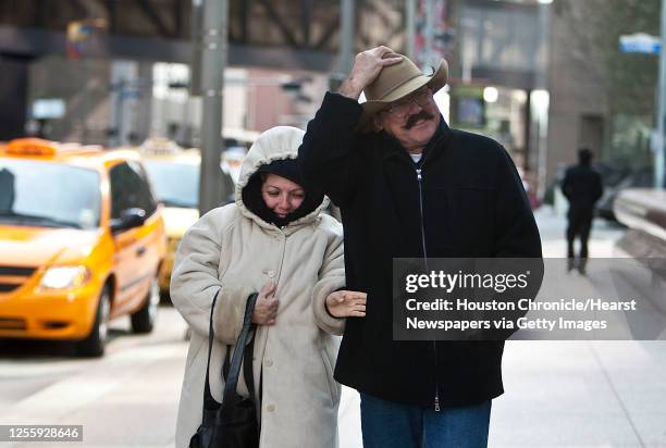 Flor Gonzalez left, and her husband Juan Gonzalez right, of Monterrey, Mexico walk along Louisiana street in downtown as a cold front moves through...