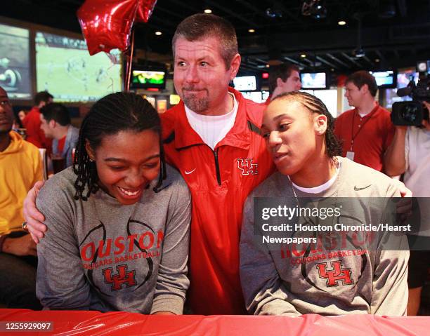 The University of Houston women's basketball team head coach Todd Buchanan center, speaks with team members Michelle White left and Jasmine Johnson...