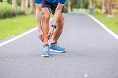 Young adult male with his muscle pain during running. runner man having leg ache due to Shin Splints. Sports injuries and medical concept