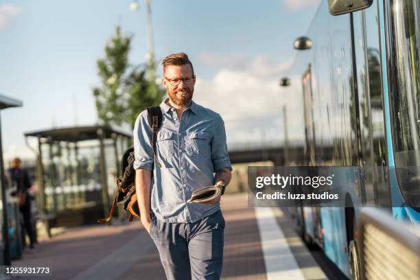 portrait of a man reading a book at the bus stop - usual stock pictures, royalty-free photos & images