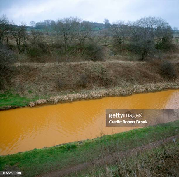 canal contaminated with minewater from abandoned cola mine - legacy of pollution from deep mining, staffordshire, uk. - acid stock pictures, royalty-free photos & images