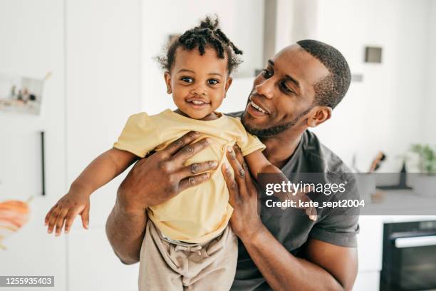 nettes kleines kleinkind und unterstützender vater - african american dad stock-fotos und bilder